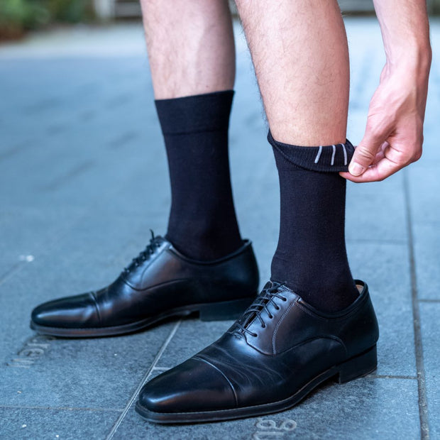 Man wearing straight up socks stay up dress socks showing the design inside the cuffs that keeps the socks up